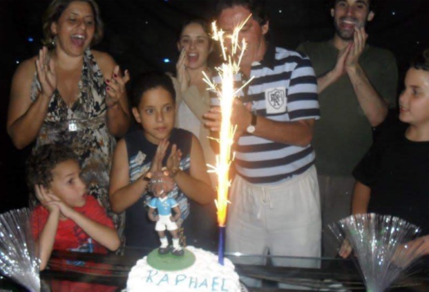 famille souriante et chantante autour d'un gateau d'anniveraire